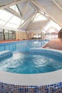 a large swimming pool with blue water in a building at Caravan LEANNE in Meliden