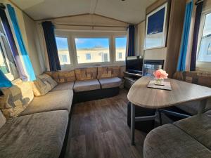 a living room with a couch and a table at Caravan LEANNE in Meliden