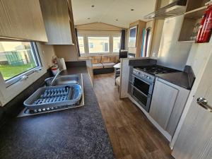 a small kitchen with a sink and a stove at Caravan LEANNE in Meliden