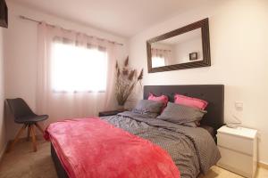 a bedroom with a bed with a mirror and a chair at Casa Allegra in Los Alcázares