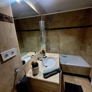 a bathroom with a sink and a tub at Casa Allegra in Los Alcázares