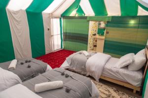 a room with two beds in a tent at Erg Chebbi Desert Luxury Camp in Merzouga