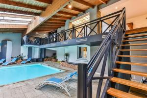 una piscina cubierta con una escalera junto a una casa en L'atypique - Maison & piscine intérieure, en Challans
