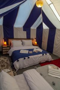 a bedroom with two beds in a tent at Erg Chebbi Desert Luxury Camp in Merzouga