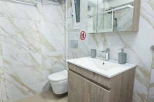y baño con lavabo y aseo. en Charming Urban Oasis 1BR Apt near Megaro Mousikis en Atenas