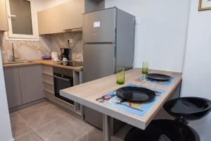 a kitchen with a counter with a refrigerator at Charming Urban Oasis 1BR Apt near Megaro Mousikis in Athens