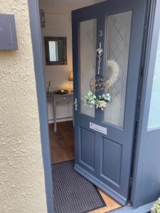 Una puerta azul con una corona de flores encima. en Hunters Lodge, with parking for one car, en Lincoln