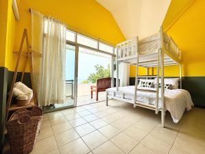 a bedroom with a bunk bed and a large window at Gao Bayview Banchang in Rayong