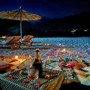 a bottle of beer sitting on a beach at night at River Beach Resort - Trishuli in Benighāt