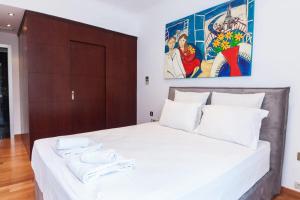 um quarto com uma grande cama branca com duas toalhas em Riviera Retreat 3 Bedroom Voula Luxury Haven Apt em Atenas