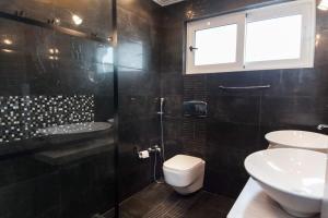 łazienka z 2 umywalkami, toaletą i prysznicem w obiekcie Riviera Retreat 3 Bedroom Voula Luxury Haven Apt w Atenach