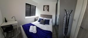 1 dormitorio con 1 cama con sábanas y almohadas azules en SAV Apartments Nottingham Road Loughborough - 1 Bed Flat, en Loughborough