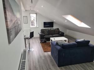 a living room with a couch and a tv at SAV Apartments Leicester - 2 Bed Cosy Flat Saffron in Leicester
