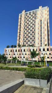 a large building with a park in front of it at Capital O 93854 Apartemen Sayana By Sentra Jaya in Bekasi