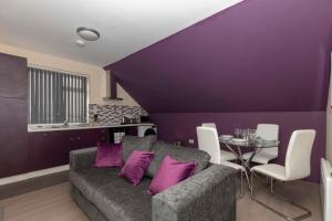 uma sala de estar roxa com um sofá e uma mesa em SAV Apartments Clarence Street-Loughborough em Loughborough