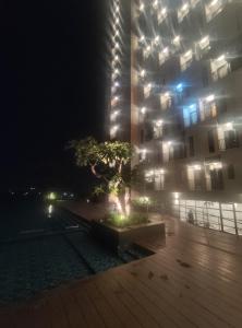 a building with a tree in front of it at night at Capital O 93854 Apartemen Sayana By Sentra Jaya in Bekasi
