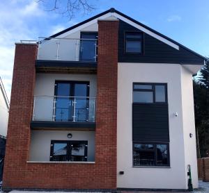 uma casa de tijolos vermelhos e brancos com uma varanda em SAV Apartments Leicester - 2 Bed Cosy Flat Saffron em Leicester