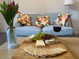 una mesa con un plato de queso y una copa de vino en The Old Gaol en Peebles