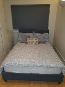 a bed with a black headboard in a bedroom at SAV Apartments Watford in Watford