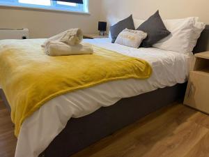 un grande letto con una coperta gialla sopra di SAV 1 Bedroom Flat near Watford Town Centre a Watford