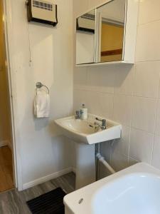 bagno bianco con lavandino e specchio di SAV 1 Bedroom Flat near Watford Town Centre a Watford