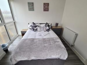 een slaapkamer met een groot wit bed met kussens bij SAV Apartments Nottingham Road Loughborough - 1 Bed Flat in Loughborough