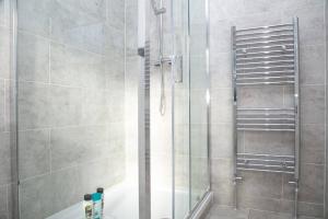 a shower with a glass door in a bathroom at SAV - 4 Bed Town House, Harrow in Harrow