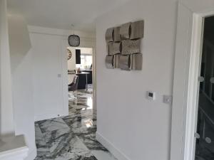 a hallway with marble flooring and towels on a wall at SAV 5 Bedroom Executive Detached House in Leicester in Humberstone