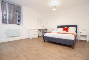 een slaapkamer met een bed, een bureau en een raam bij SAV Apartments Regent Leicester in Leicester