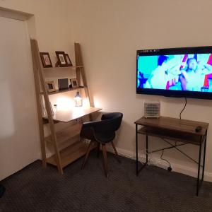 a living room with a television and a table and a chair at Family-friendly Studio flat in Dagenham in Dagenham