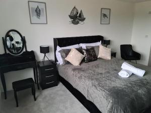 a bedroom with a bed and a desk and a mirror at SAV 5 Bed Luxury House Leicestershire in Humberstone