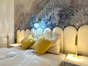 een slaapkamer met een wit bed met gele kussens bij Art Hotel Vienna in Wenen