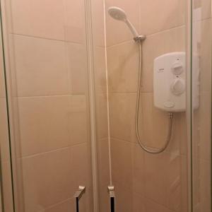 a shower with a shower head in a bathroom at Family-friendly Studio flat in Dagenham in Dagenham