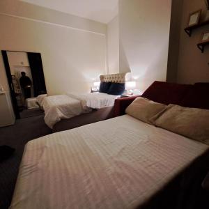 a hotel room with two beds and a mirror at Family-friendly Studio flat in Dagenham in Dagenham