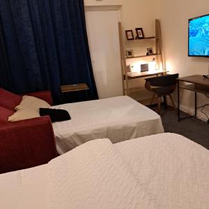um quarto de hotel com duas camas e uma televisão em Family-friendly Studio flat in Dagenham em Dagenham