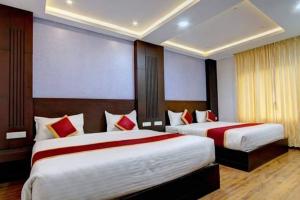 um quarto de hotel com duas camas com almofadas vermelhas em Hotel Le Castle em Kodaikanal