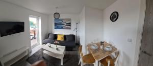 ein Wohnzimmer mit einem Tisch und einem blauen Sofa in der Unterkunft SAV Apartments Loughborough - 1 Bed Flat in Loughborough