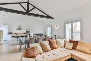 sala de estar con sofá grande y cocina en Côté Plage - Appartement 100m vue mer, en Saint-Jean-de-Monts