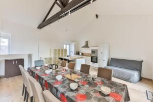 a dining room with a table and chairs and a kitchen at Côté Plage - Appartement 100m vue mer in Saint-Jean-de-Monts