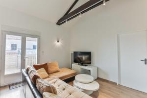 sala de estar con sofá y TV en Côté Plage - Appartement 100m vue mer, en Saint-Jean-de-Monts