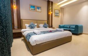 a hotel room with a bed and a blue chair at Hotel Dream Inn in Rishīkesh