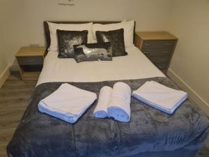 Una cama con toallas y almohadas. en SAV Apartments Loughborough - 1 Bed Flat, en Loughborough