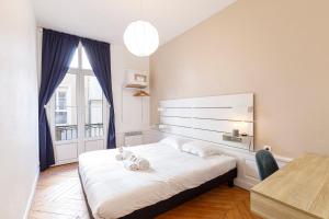 a bedroom with a bed with two stuffed animals on it at Le Saint-Aubin appartement chic et moderne in Angers