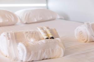 a bed with white towels and a glass of wine at Studio spacieux proche gare in Angers