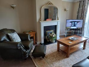 sala de estar con sofá, mesa y chimenea en 3-Bed bungalow near Conwy valley close to Castle, en Colwyn Bay