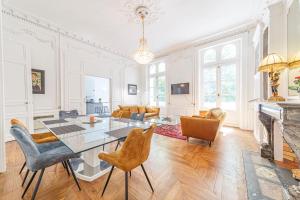a living room with a table and chairs and a fireplace at Le Roi René appartement Haussmannien in Angers