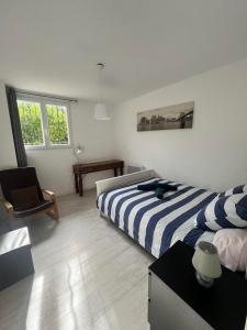Un dormitorio con una cama y una silla dentro. en Charmant T2 calme , climatisé et piscine privée, en Marsella