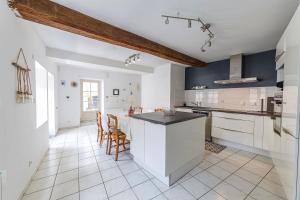 a kitchen with white cabinets and a large island at Loire-side house near Angers in Bouchemaine