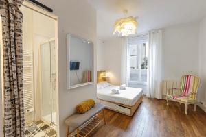 - une chambre avec un lit, un miroir et une chaise dans l'établissement Le Morphée - Appartement avec jardin, à Angers