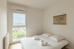 a bedroom with a bed with two towels on it at Le Jean Moulin - Appartement à 2 pas du tramway in Angers